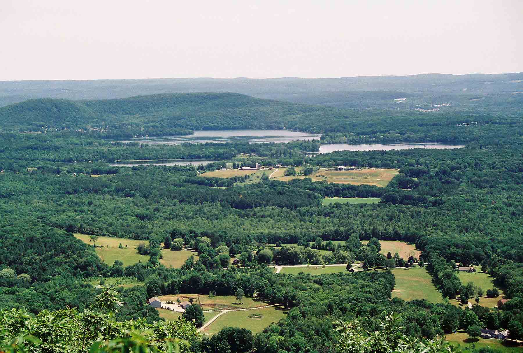 mm 4.7 - View east from ledge on main Lions Head summit.  The two lakes visible are Twin Lakes in Salisbury.  Courtesy dlcul@conncoll.edu
