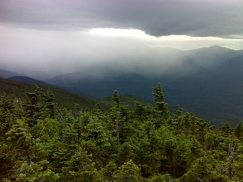 mm 10.5 Looking west towards the Presidentials from viewpoint just north of summit of Middle Carter. Rain is moving in, shrouding Mt. Washington. GPS N44.3035 W71.1681  Courtesy pjwetzel@gmail.com