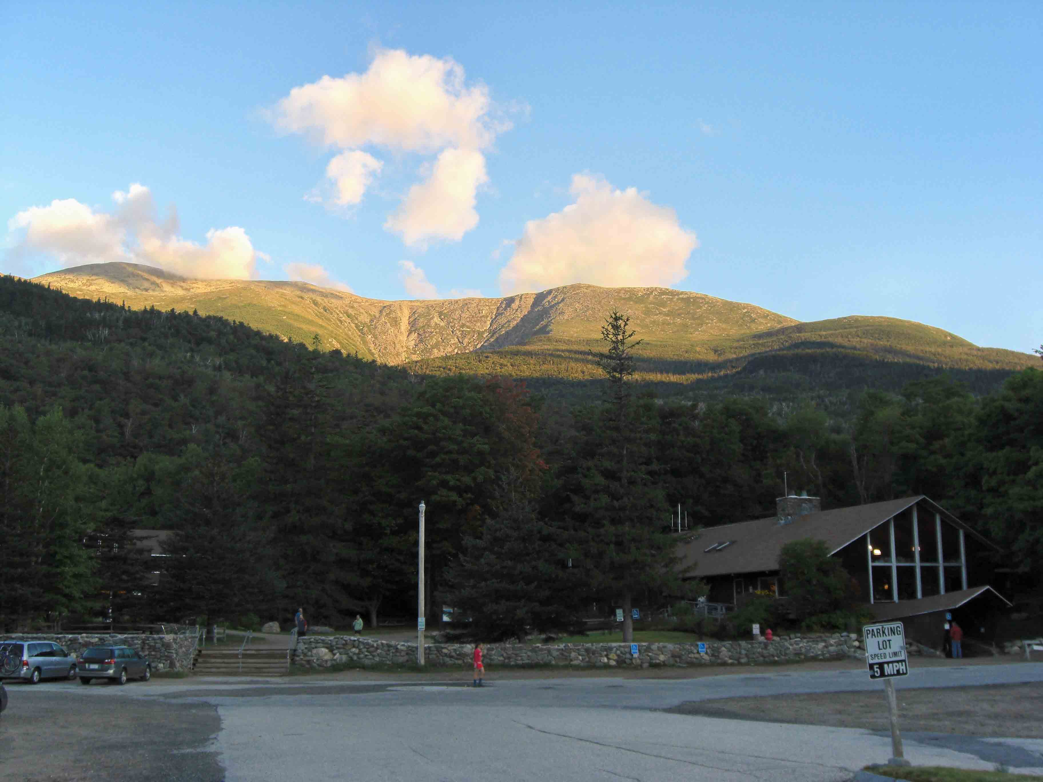 MM 0.0 - Early morning picture at Pinkham Notch Visitor Center. Huntington's Ravine and Mt. Washington are in the background. Most of the parking is to the left of this picture.  Courtesy seqatt.net@sbcglobal.net