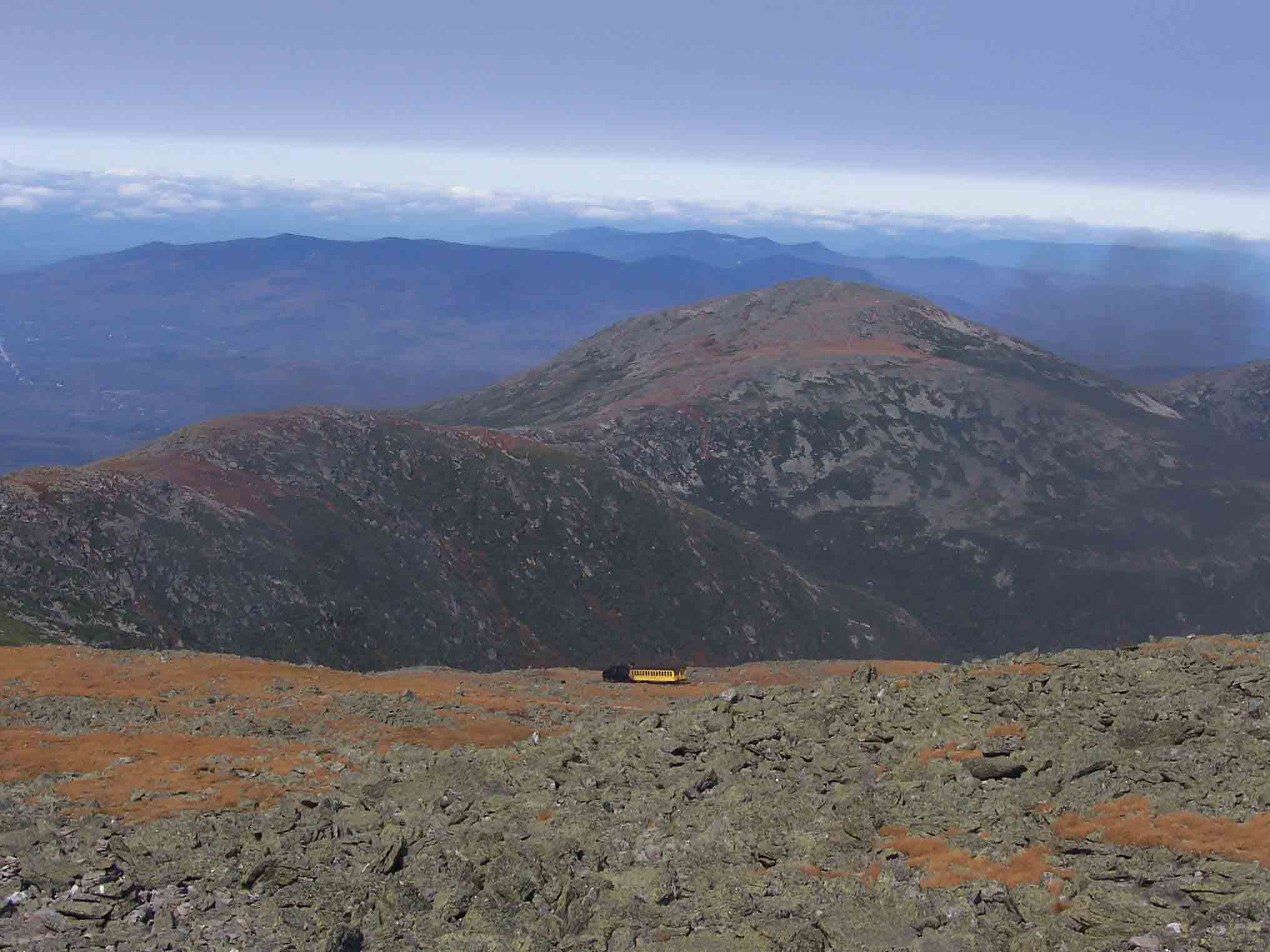 View north from north side of Mt. Washington. Mt. Jefferson is prominent peak in picture. The smaller peak in front of it is Mt. Clay which if the New Hampshire legislature has its way will become Mt. Reagan Note the cog railway train descending the mountain. Taken from approx. Mile 13.3.   Courtesy dlcul@conncoll.edu