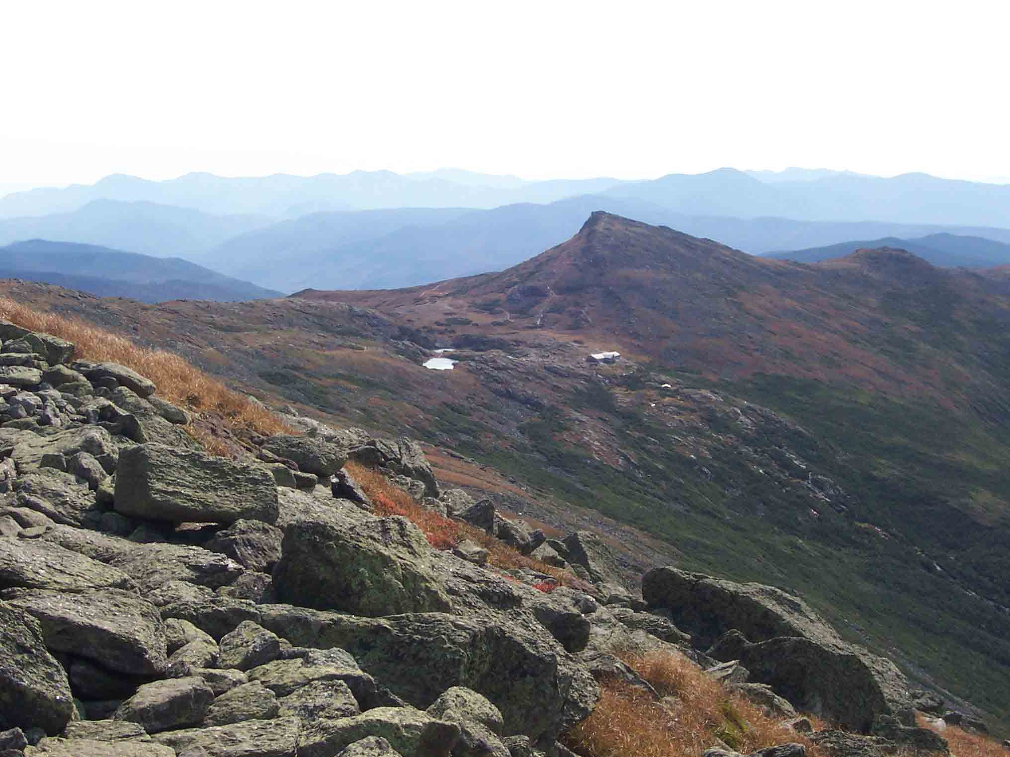 View south from west side of Mt. Washington. This was actually taken from the blue-blazed West Side Trail. It shows Lake of the Clouds Hut which the AT passes and Mt. Monroe (the peak behind the hut) which the AT skirts to the east. The southbound AT mostly follows the ridge of the Southern Presidentials to Crawford Notch State Park.  Courtesy dlcul@conncoll.edu