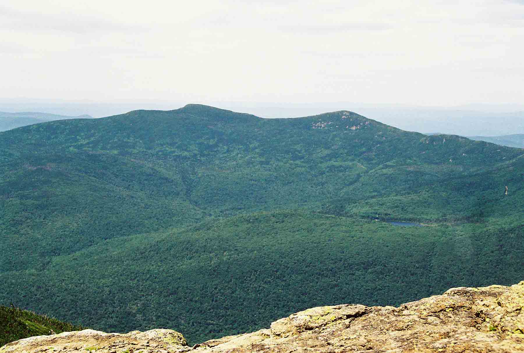mm 22.3 - Looking west across Franconia Notch from Mt. Lincoln. Two peaks are North (on right) and South Kinsman. Lonesome Lake is also visible.  Courtesy dlcul@conncoll.edu