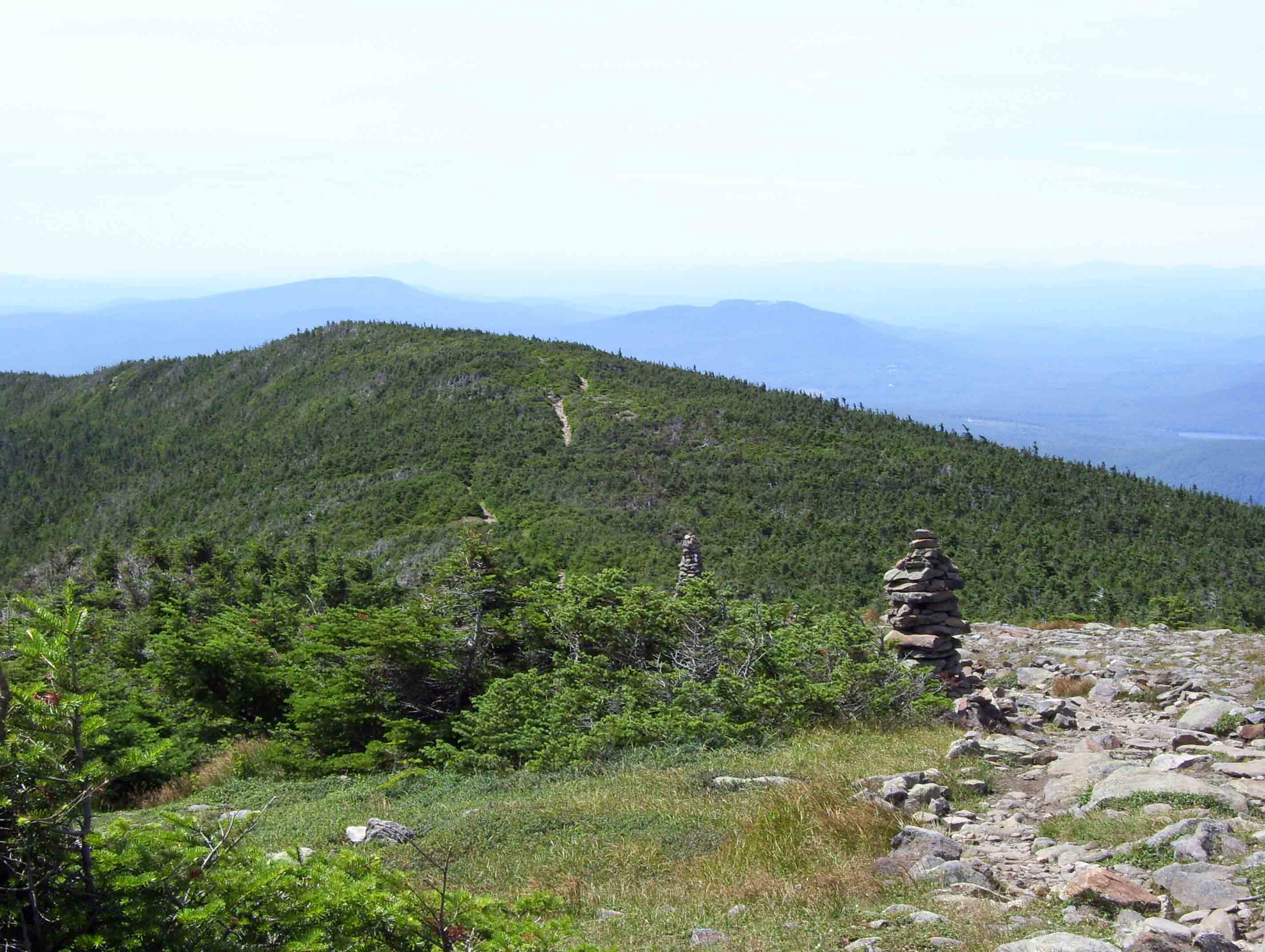 View south along the ridge of Mt. Moosilauke on 8/9/07. The AT here follows the old Carriage Road which used to bring people to the hotel on the summit. Note the two peaks in the distance. The closer is Mt. Cube while the further one is Smarts Mt., both of which the AT to the south crosses. Taken from approx. Mile 3.9.  Courtesy dlcul@conncoll.edu