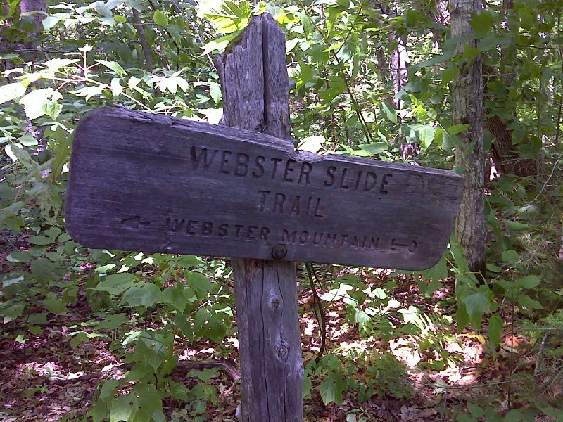 mm 2.2 Junction with Webster Slide Trail which leads a mile west to a viewpoint on Webster Slide Mountain. An unmarked trail goes east to Wachipauka Pond in 0.2 miles.    GPS  N43.9832 W71.9281  Courtesy pjwetzel@gmail.com