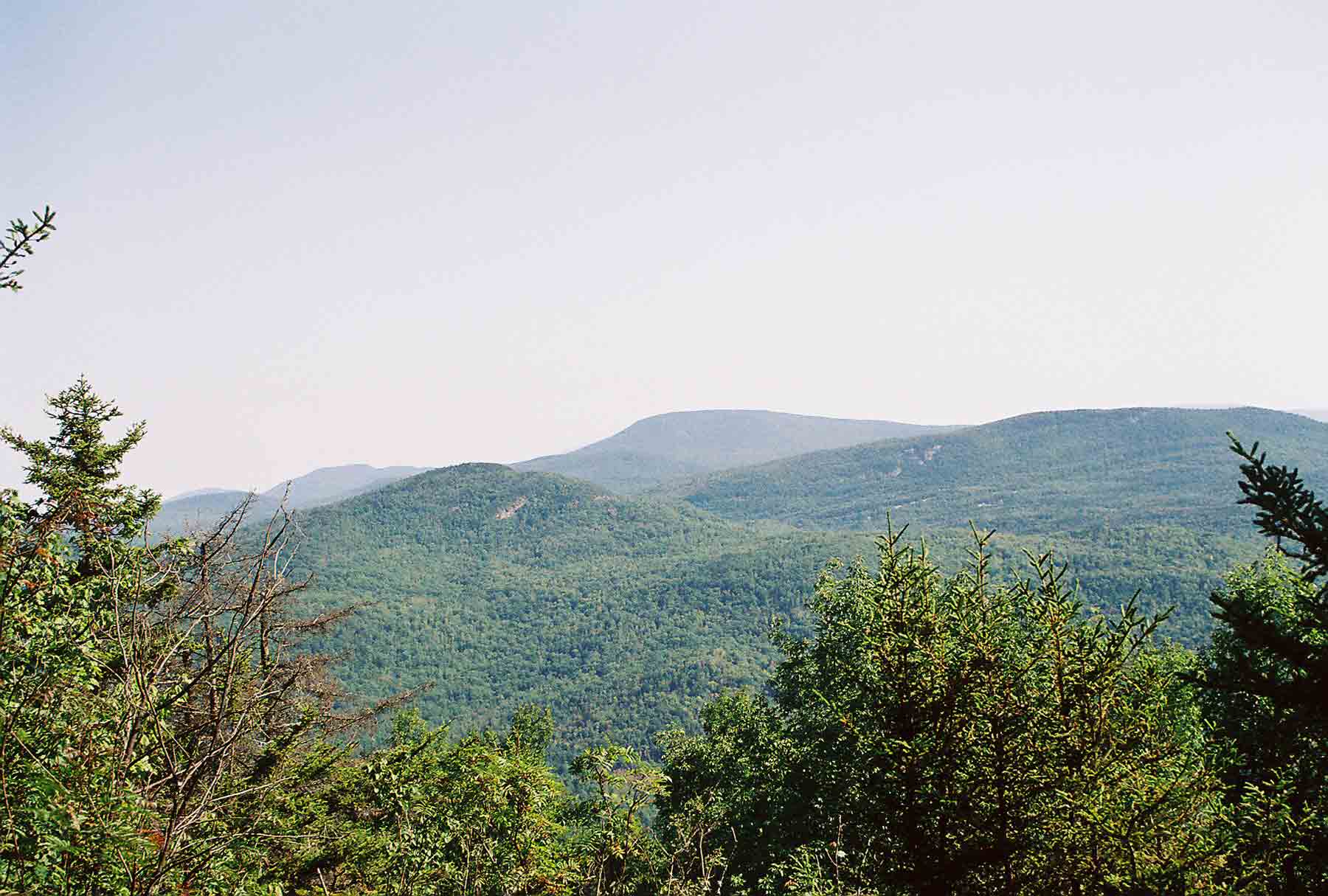 View from ledge at approx. Mile 4.9 on north side of North Moose Mt. Large peak is Smarts Mt. The one in foreground is Holts Ledges. The peak in the distance and to the left of Smarts is Mt. Cube. The AT climbs all three. Courtesy dlcul@conncoll.edu