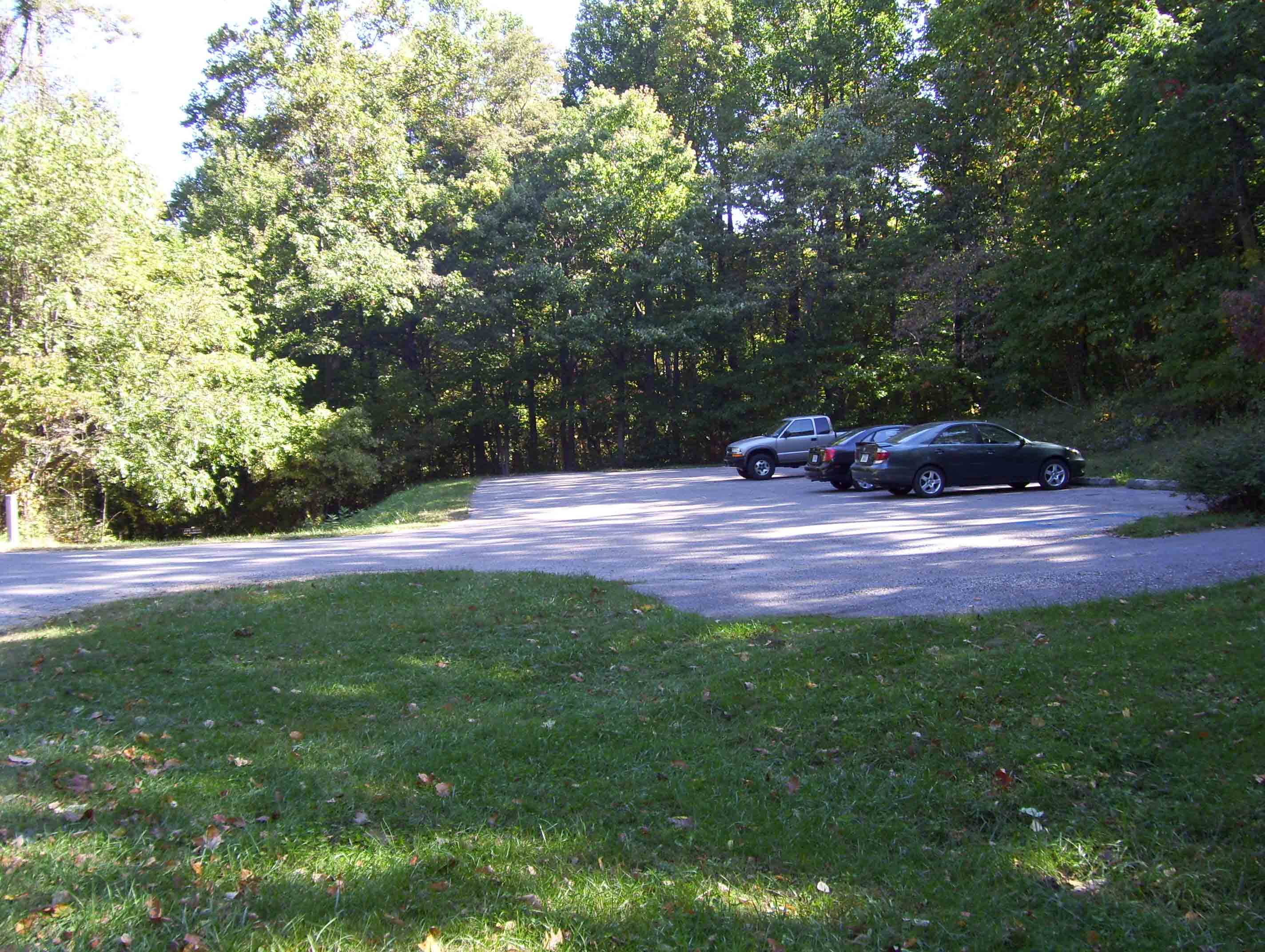 View of Parking Area at Jarman Gap. The Moormans River Fire Road starts at the grassy area on the left side of the lot and goes downhill to meet the AT at mile 13.9. The Bucks Elbow Mt. Fire Road goes to the right from the nearer end of the lot and meets the AT in 0.1 miles (Mile 14.1 of Section 13 or Mile 0.0 of Section 14).  Courtesy dlcul@conncoll.edu