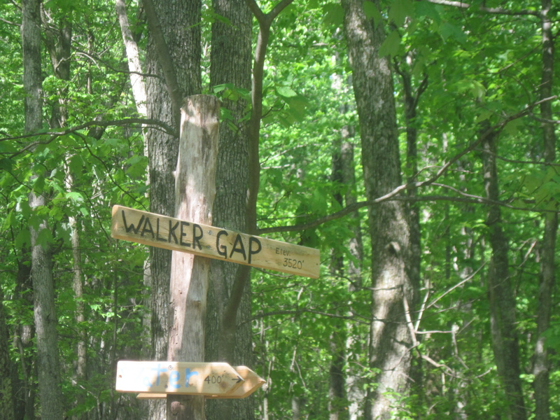 Sign for Walker Gap at intersection with a trail to a water source. Taken at approx. mm 4.7. There are apparently currently (2011) two routes just north of the parking in Walker Gap.  The older trail goes over a knoll then descends to the parking.  The new route which is (or will be) the official AT route goes around the knob.  It has unusual markings of parallel blue and white blazes. This is the route I took.   Courtesy dlcul@conncoll.edu