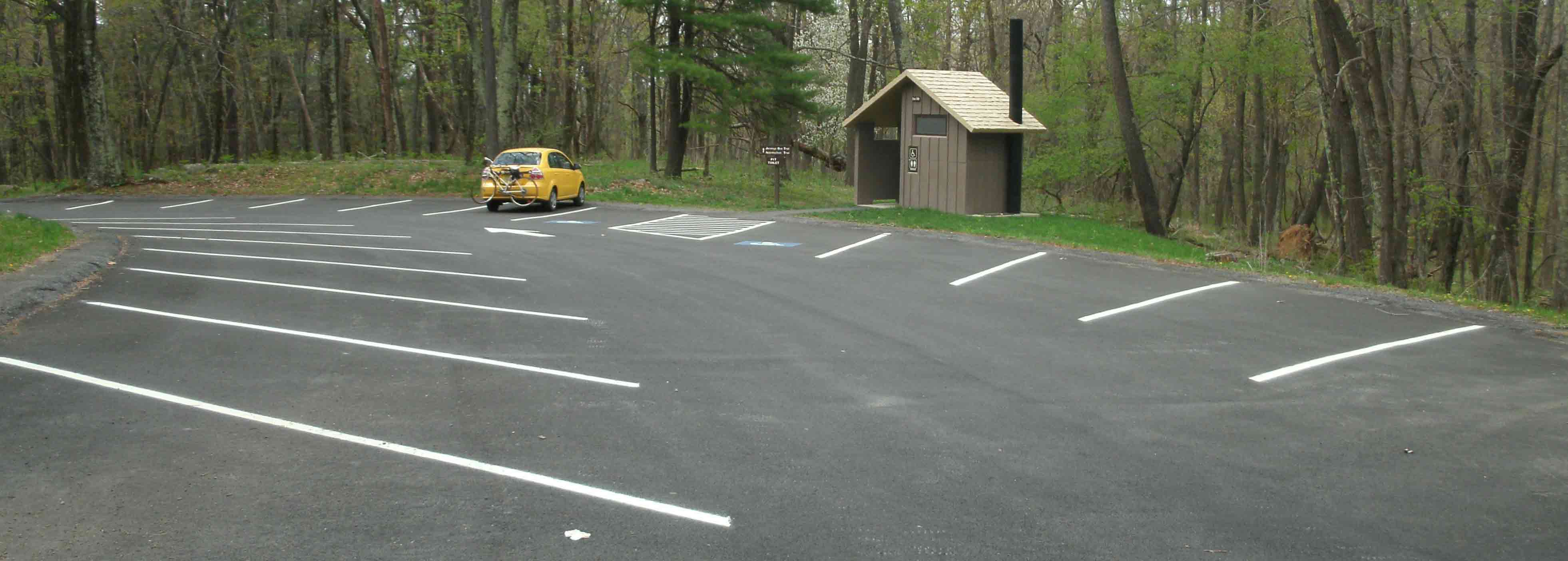 mm 6.3 While there is ample parking at Elkwallow Picnic Area, it is for day parking only. This photo shows just a few of the scores of parking spaces here. The spur trail to the AT is just to the left of the outhouse shown here.  Courtesy MalteseCross@Comcast.net