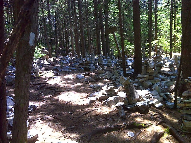 mm 8.3  Hikers have created this cairn city at the intersection with the trail to the White Rocks Viewpoint.   GPS N43.4430 W72.9425  Courtesy pjwetzel@gmail.com